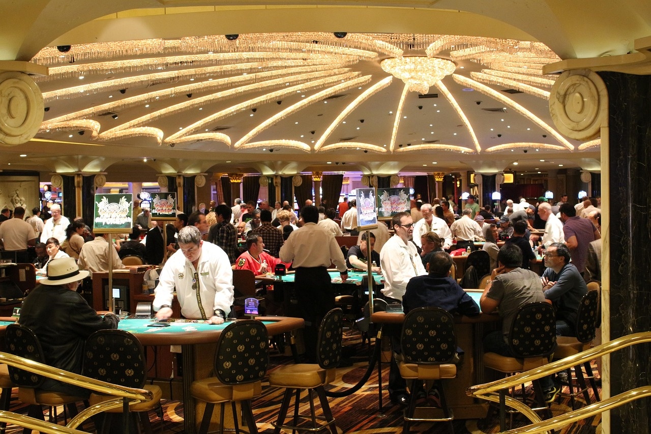 Evening casino lounge interior with chandelier light and hosted gaming tables