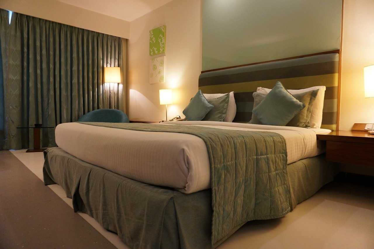 Premium suite with teal drapes, striped linens and warm lamps at night
