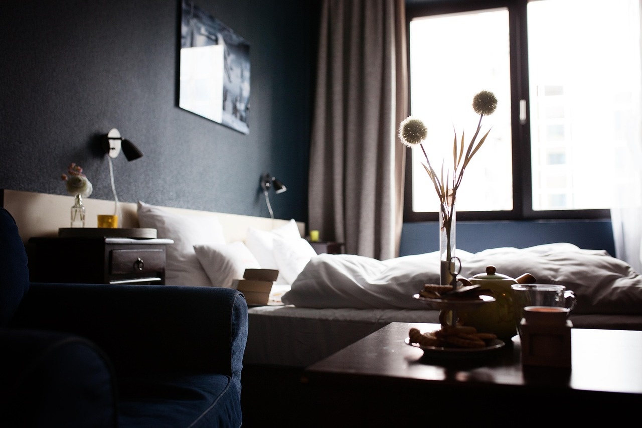 Guest room with walnut furniture, ivory bedding and afternoon tea service