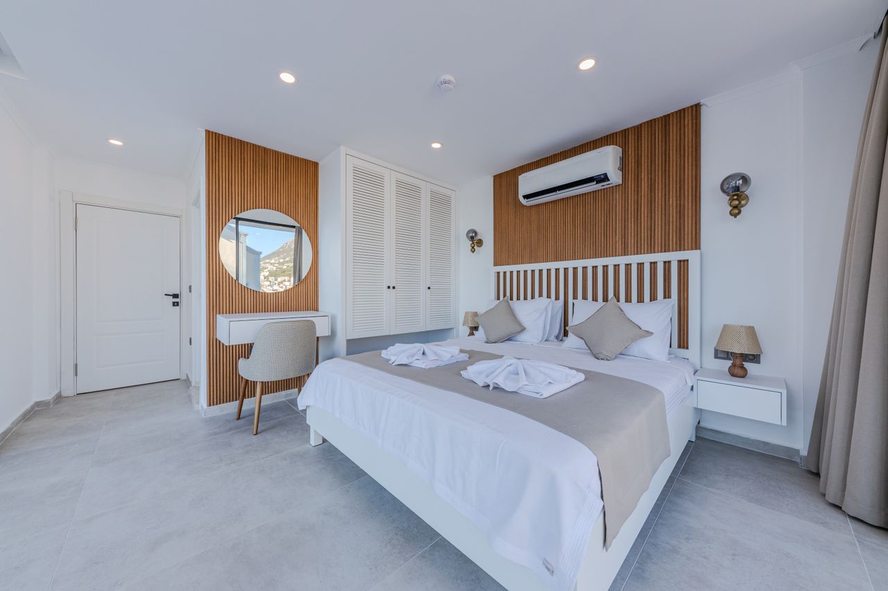 Contemporary manor guest room with oak slat walls, brass globes and a circular mirror