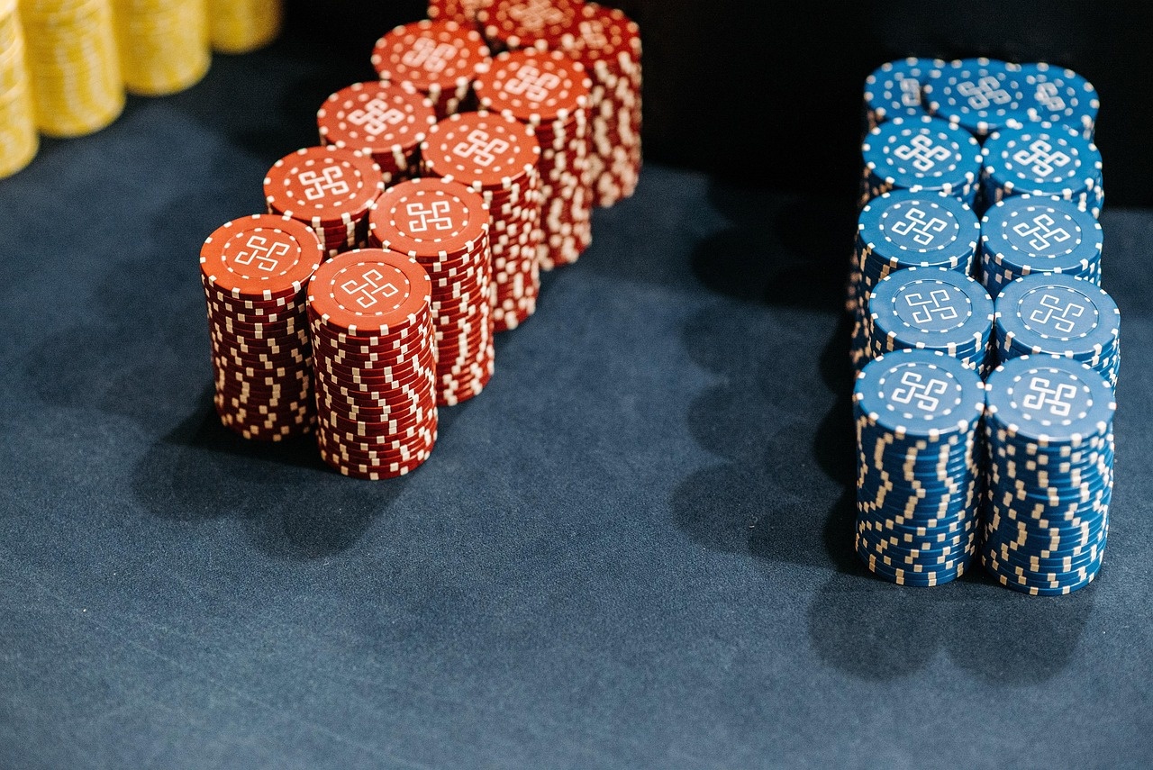 Stacks of burgundy and navy chips on a midnight-blue gaming cloth