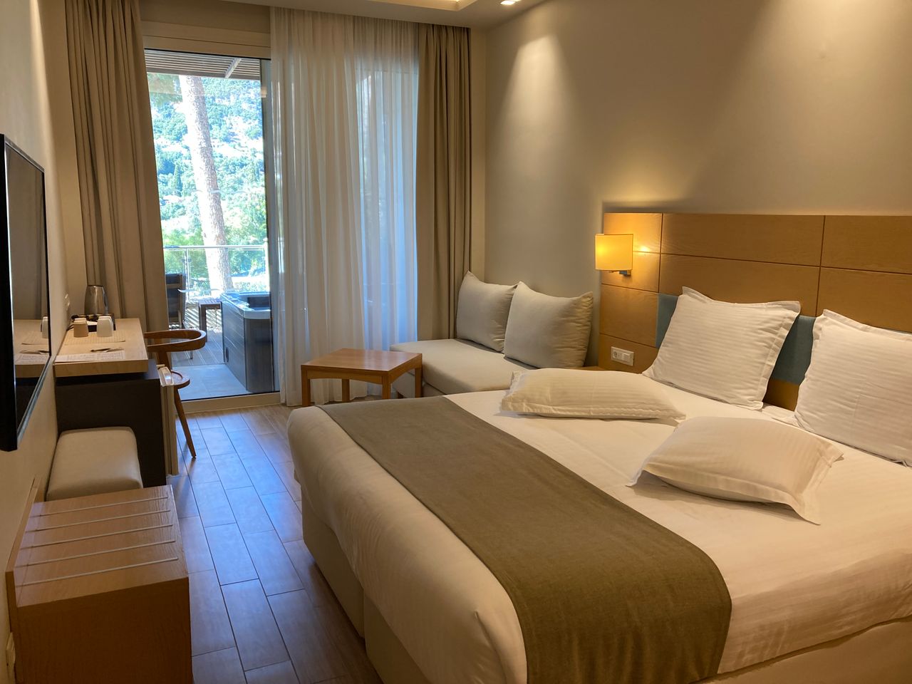 Executive room with seating area, desk and a private balcony overlooking greenery