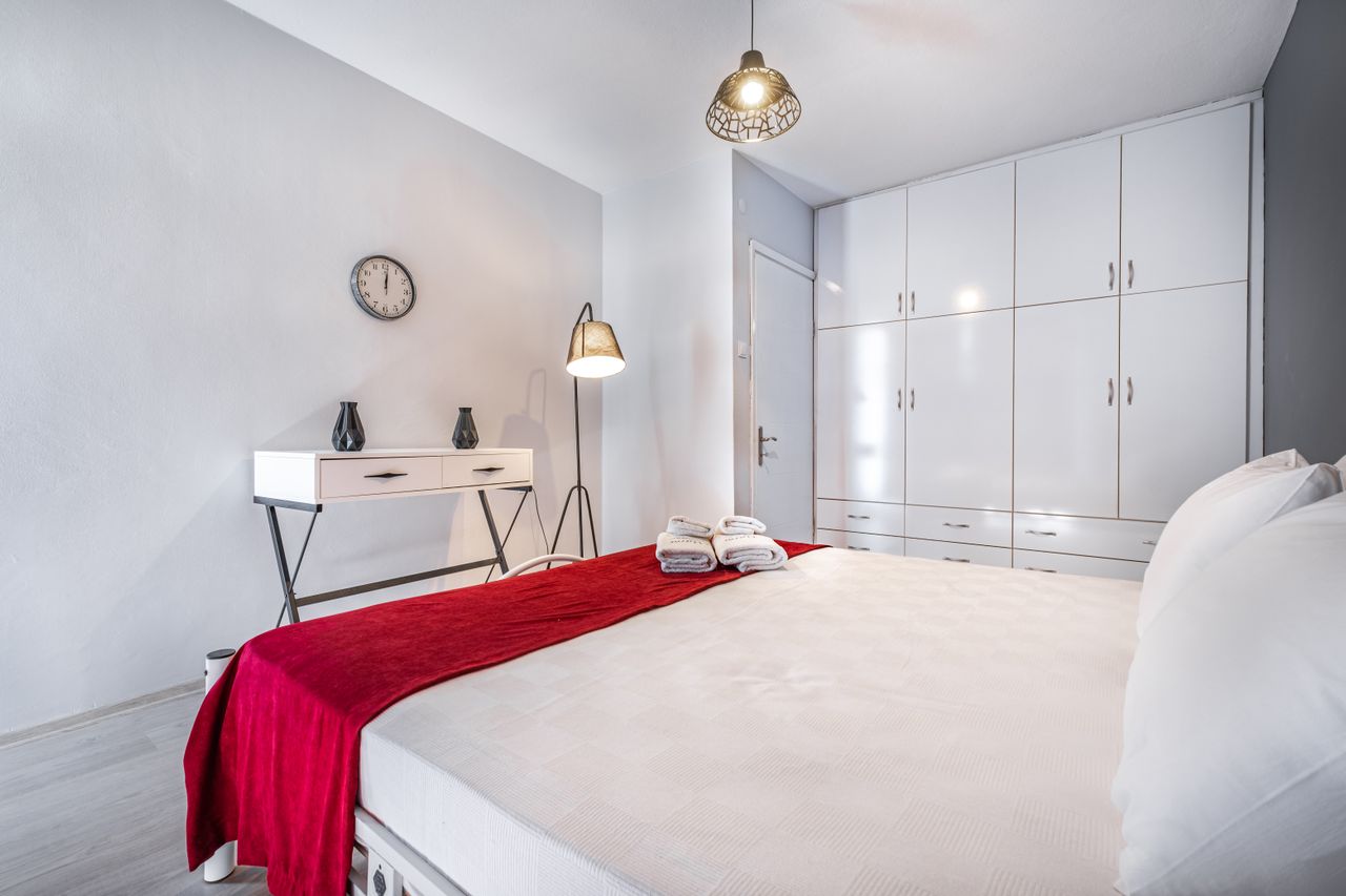 Classic room with white linens, a red runner and a minimal black floor lamp